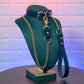 Blue leather collar with gold chain leash on a green mannequin against a textured purple and blue background