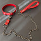 Red leather collar with chain leash on a gray surface