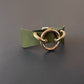 Green leather choker with gold metal hardware on a dark gray background