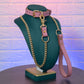 Pink bondage collar and leash set on a green mannequin bust against a textured purple wall.