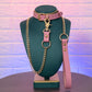 Pink collar and leash set on a green mannequin against a textured purple and blue background