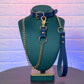 Blue leather choker with gold chain on a green mannequin bust against a textured white wall.