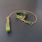 Green leather collar with gold chain on a dark gray background