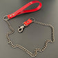 Red leather curb chain leash on a gray background