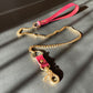 Gold chain bondage leash with marsala leather handle on a gray surface