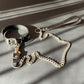 BDSM collar with chain and leash on a gray surface