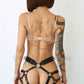Leather belt with garters. Back view on model shows how the harness emphasizes the buttocks. Demonstrates how the belt will sit on the body. Dark nickel hardware, black leather.