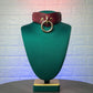 Marsala mannequin head with a brown leather belt and gold ring on a textured white background