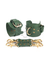 Green leather handcuffs with two connectors and carabiners lie side by side, one handcuff is shown from the side of the buckle and lies half sideways the second handcuff stands half sideways and is shown from the side of the D-ring for which the carabiner is fixed. Gold hardware. 