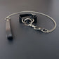 Black leather collar with silver chain and strap on a dark surface