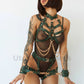 Leather harness with open bust and chains, leather garter belt open butt and crotchless, and handcuffs fastened together. Close-up front view. Green leather, gold hardware.