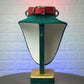Green lamp with a red collar on a textured white background