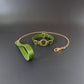 Green leather collar with gold chain leash on a dark gray background