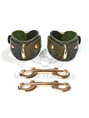 The handcuffs are wave-shaped and are shown from the side of the D-rings to which carabiners and other bondage accessories can be attached. There are two double carabiners next to each other.
Green leather, gold hardware. Front view.