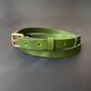 Green leather choker with a gold buckle on a gray background