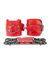 Red leather handcuffs with two connectors with carabiners are lying side by side, one handcuff is shown with a buckle and it stands on a rib, the second handcuff is shown with a D-ring for which the carabiners are attached and it also stands on a rib. Front view. Dark nickel hardware. 
