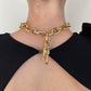 Gold chain choker necklace worn by a person against a neutral background