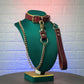 Green mannequin head with leather collar and gold chain leash a textured wall background