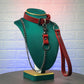 Green mannequin head with red leather collar and leash on a textured white background