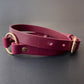 Marsala leather collar with gold hardware on a gray background