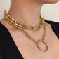 Gold chain necklace on a person against a neutral background