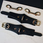Black leather hardware with gold hardware on a marble surface