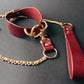 Red leather collar with gold chain on a dark background