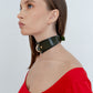 Woman wearing a green choker necklace against a white background