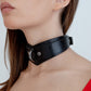 Black leather choker worn by a person on a white background