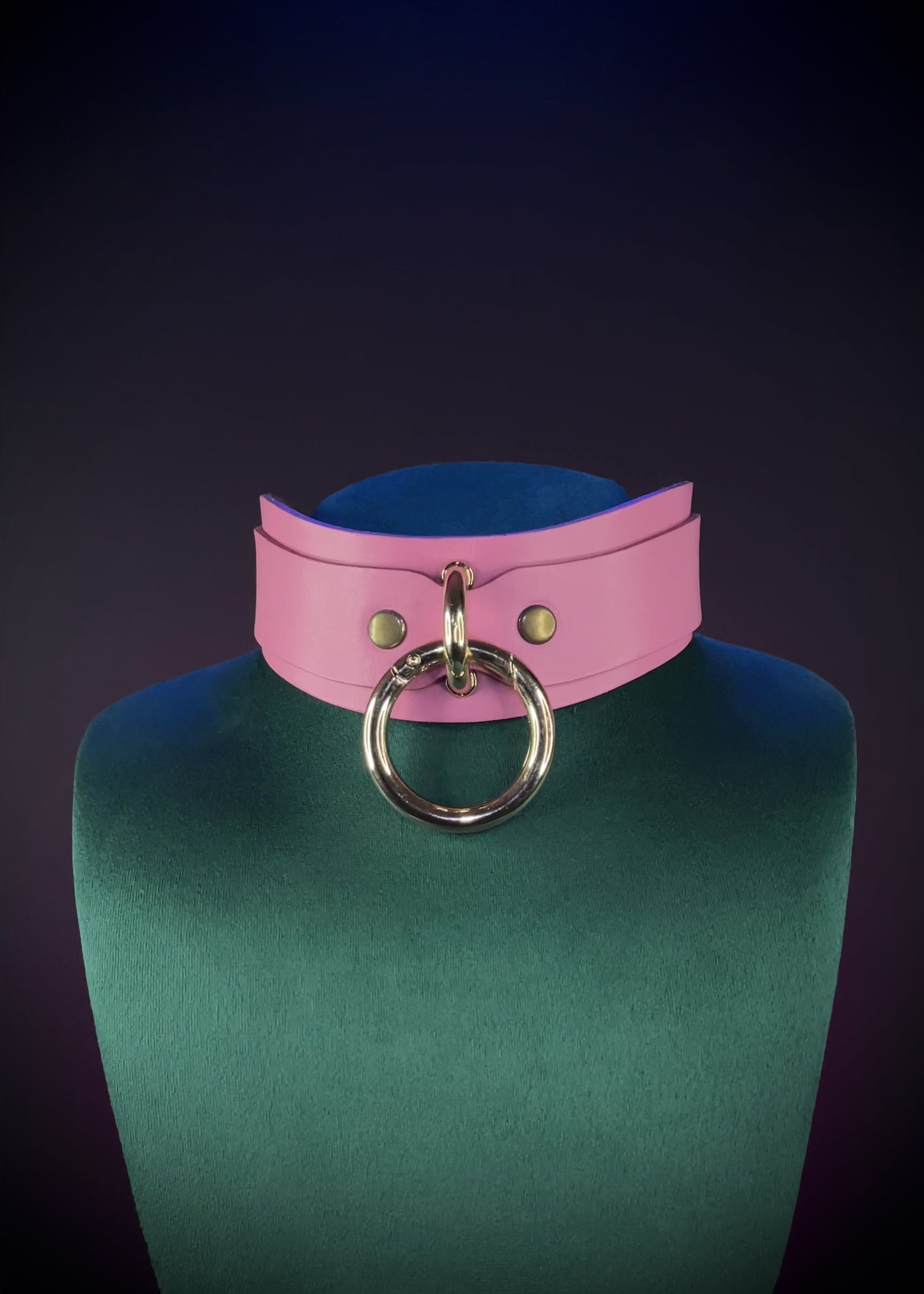 Pink leather collar on a green mannequin 